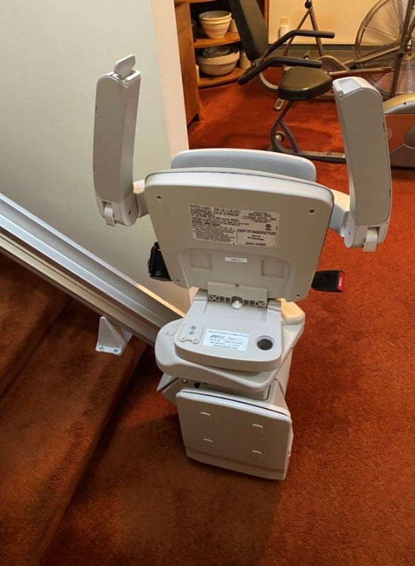 stairlift with seat and components folded up installed by Lifeway Mobility Rochester MN