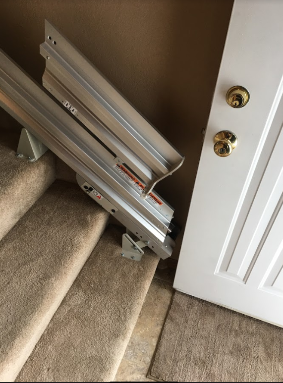 Bruno manual folding rail to prevent tripping hazard at bottom landing of stairs