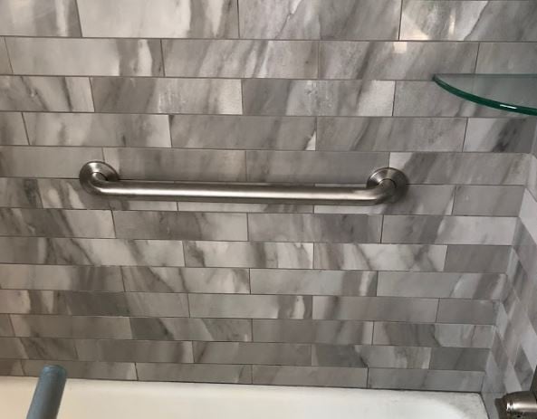 polished grab bar installed horizontally in bath tub in Minnesota home