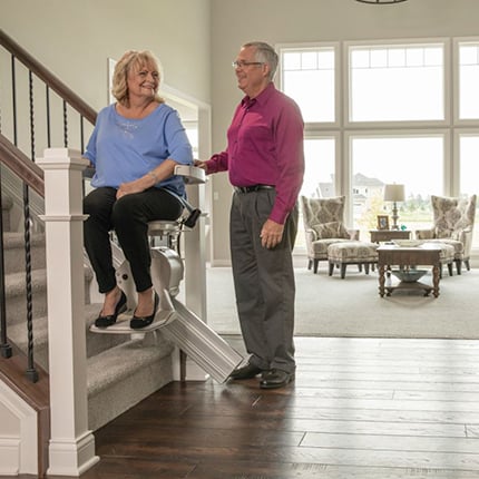 Senior couple in home - wife riding Bruno Elan stairlift in Cleveland, OH
