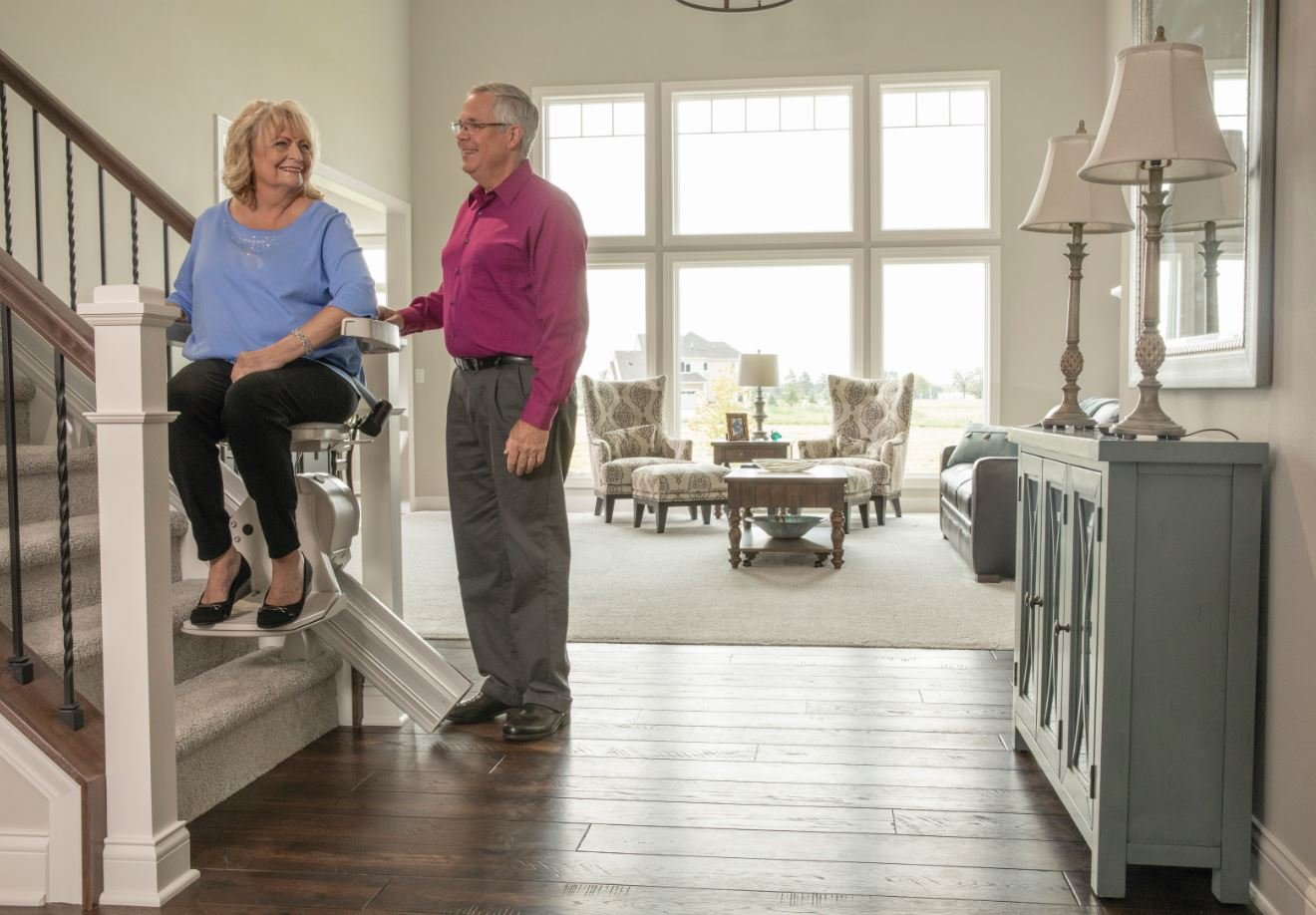 husband watching his wife ride her new stair lift