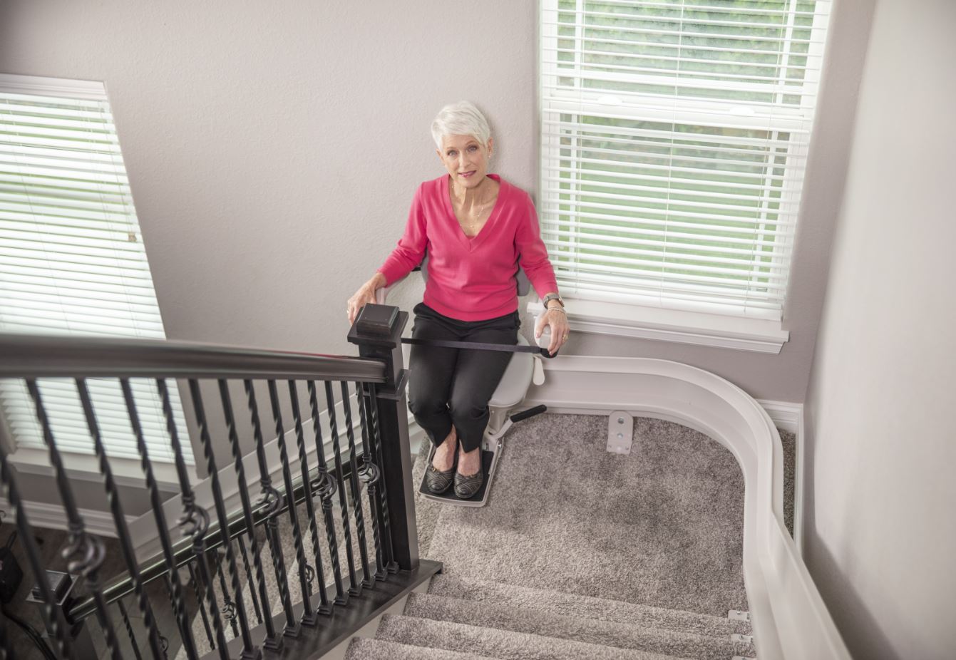 Woman riding a Bruno curved stairlift