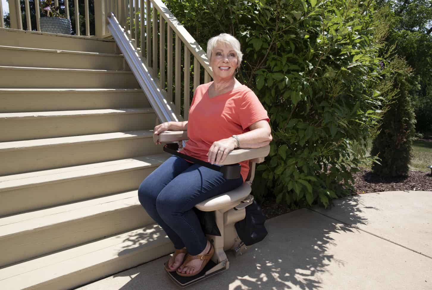 woman riding new outdoor Bruno stairlift from Lifeway Mobility
