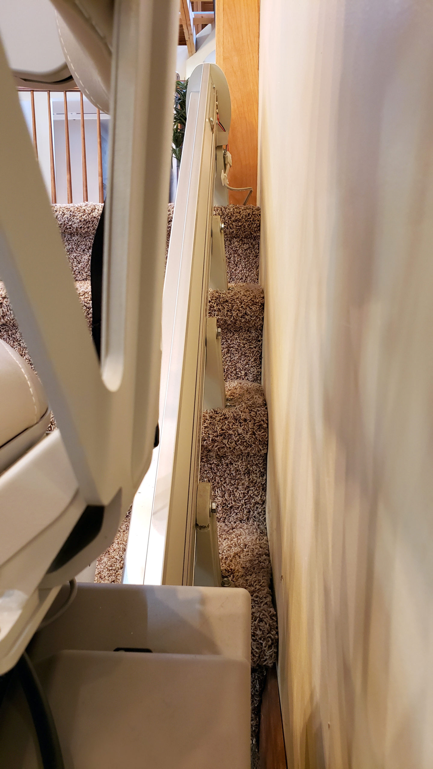 close photo showing stair lift installed on treads of stairs and not the wall