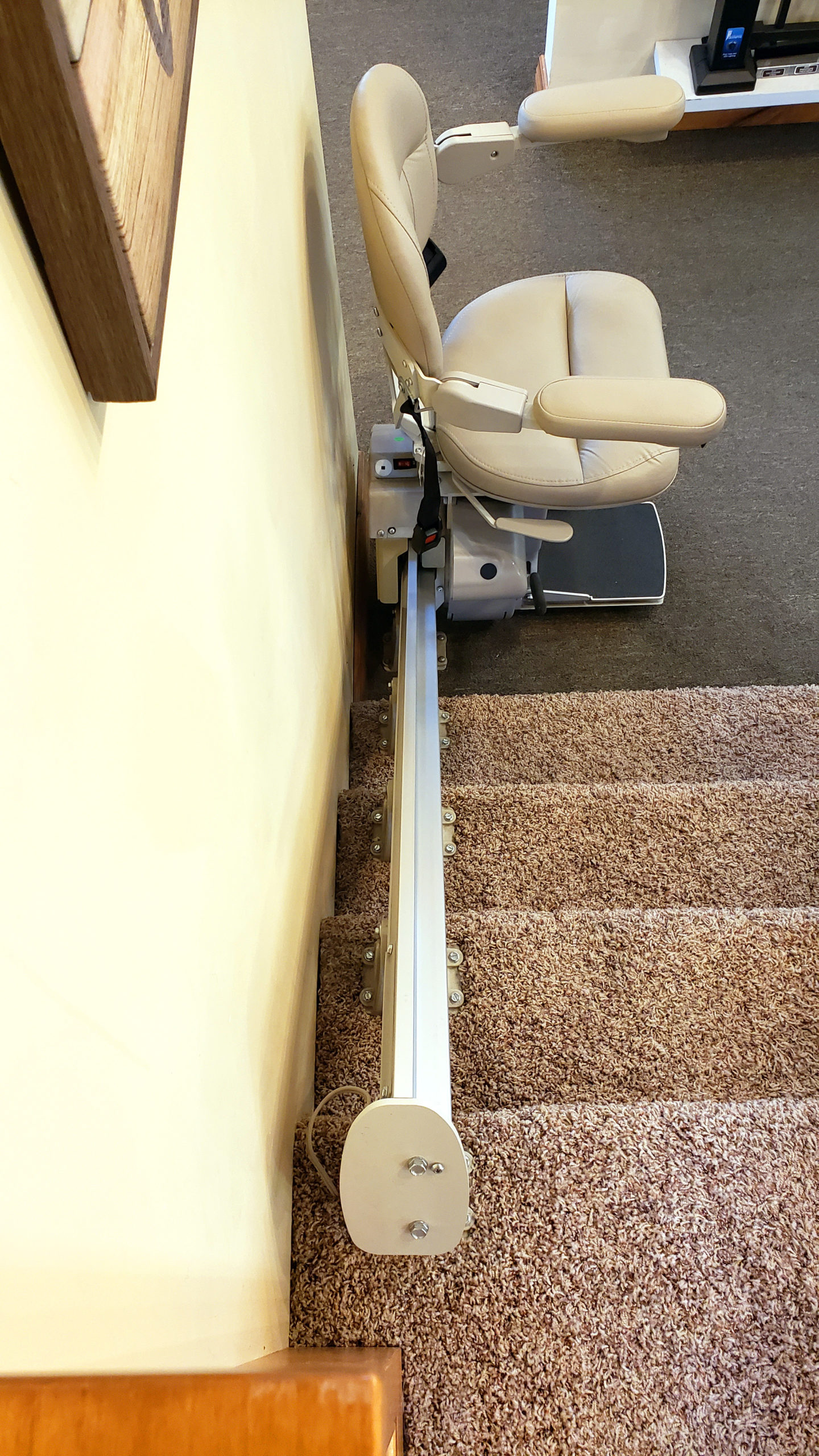 top view of stair lift rail installed on treads of stairs, not damaging walls