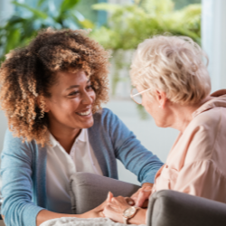 therapist helps senior woman at senior living faclity