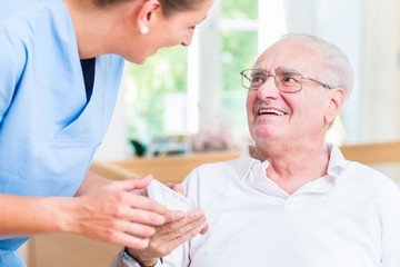 nurse helping senior in wheelchair