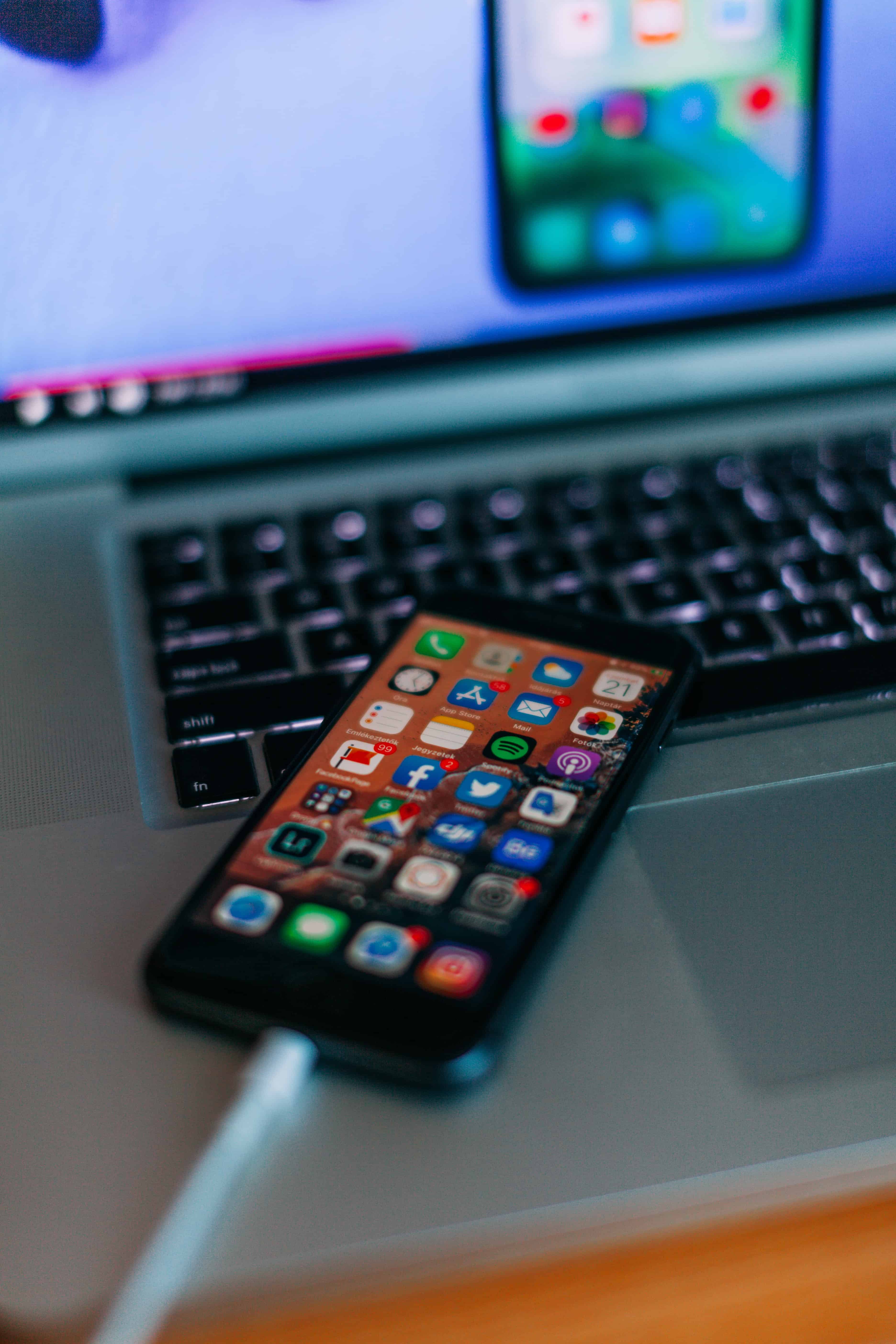 iphone charging on top of a laptop