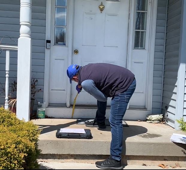 Lifeway Mobility consultant taking measurements of front entrance with gloves and face mask