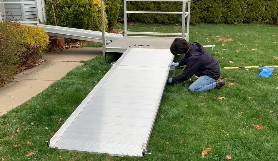 Lifeway technician installing wheelchair ramp while wearing protective gloves