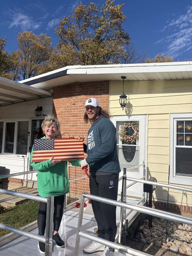U.S. veteran's wife and Eagles player smiling on the wheelchair ramp installed by Lifeway Mobility for her husband