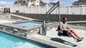 man in pool lift to safely transfer into the pool