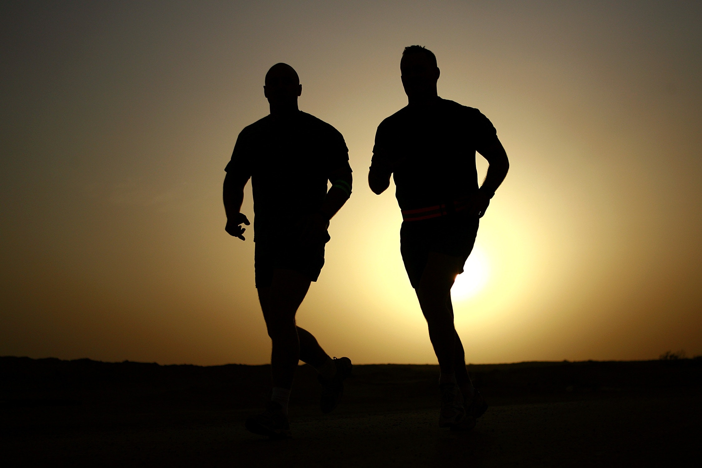 men running at sunset in preparation for a marathon
