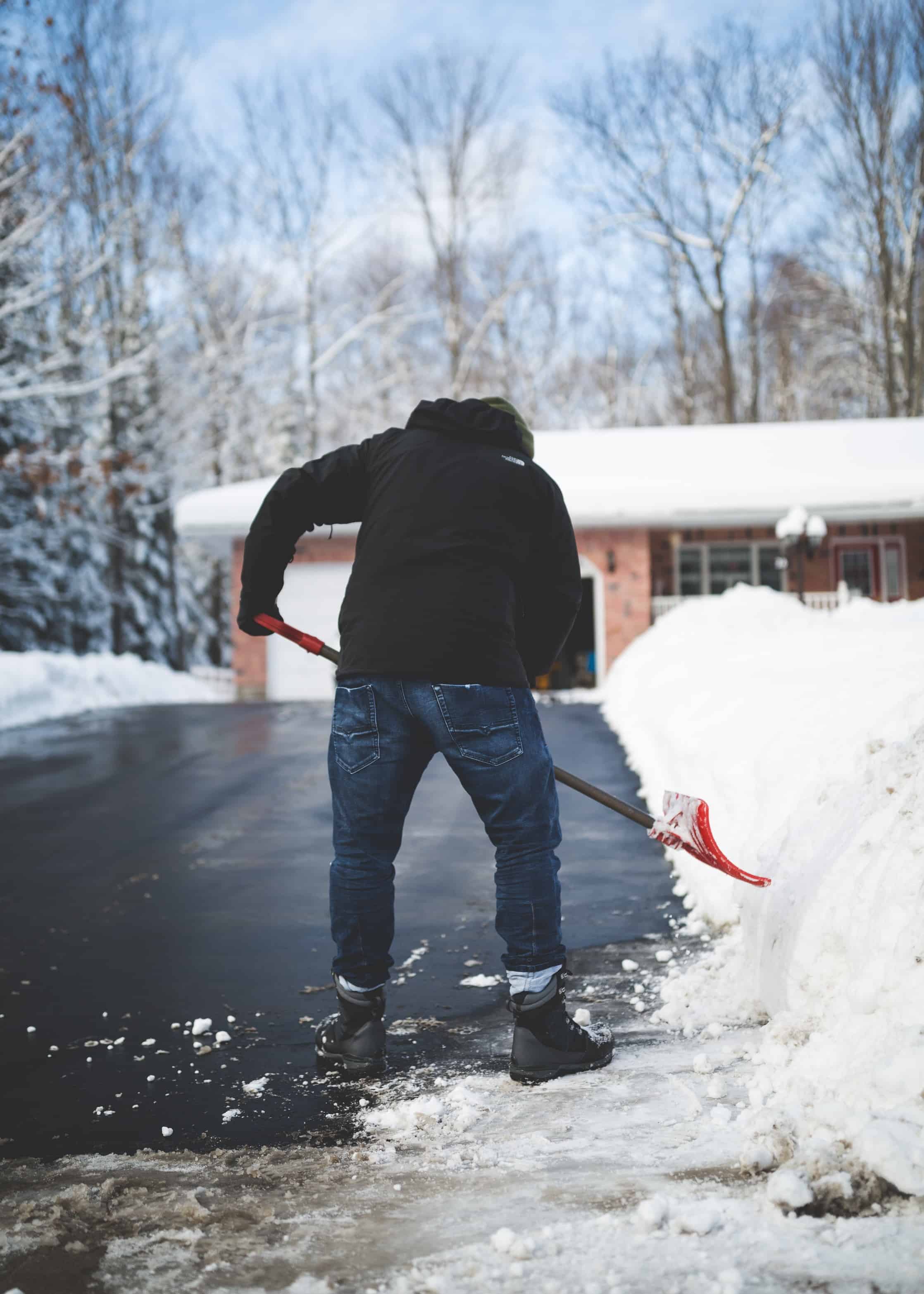man-shoveling-snow-to-clear-path-for-access-to-driveway-and-porch