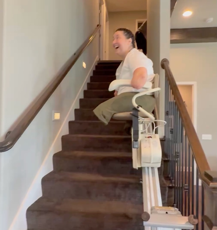 Brie riding her new stair lift installed by Lifeway Mobility