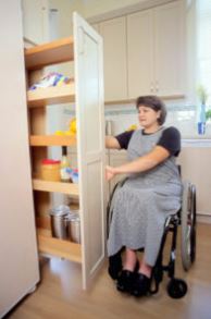 woman in wheelchair using accessible cabinet