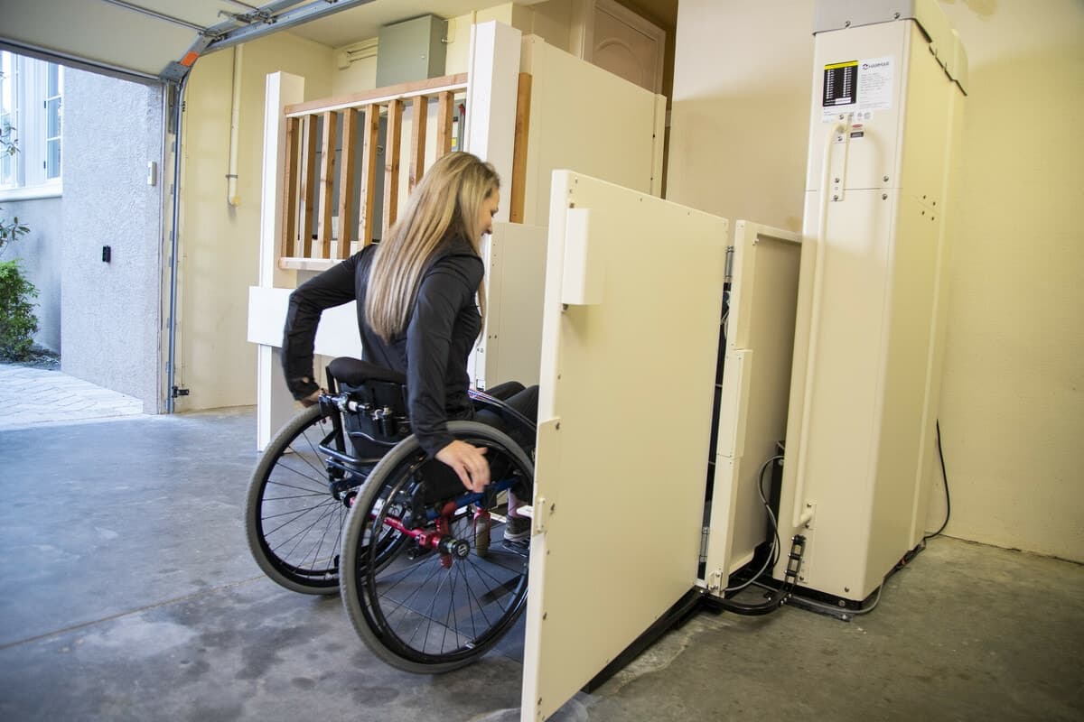 woman in wheelchair rolls onto Harmar Highlander II VPL from Lifeway Mobility