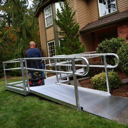 man riding scooter onto his wheelchair ramp installed by Lifeway Mobility