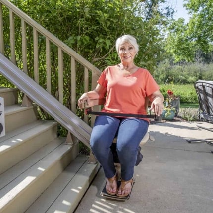 Woman riding Bruno Elite Outdoor Stair Lift in Connecticut