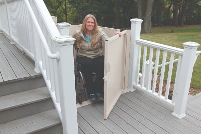 woman exiting wheelchair lift at top landing of staircase