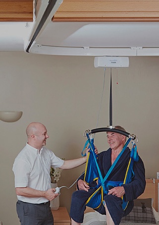 man being transferred by fixed ceiling lift by Lifeway Mobility