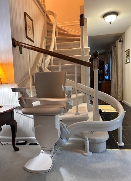 Otolift curved stair lift parked at bottom of stairs
