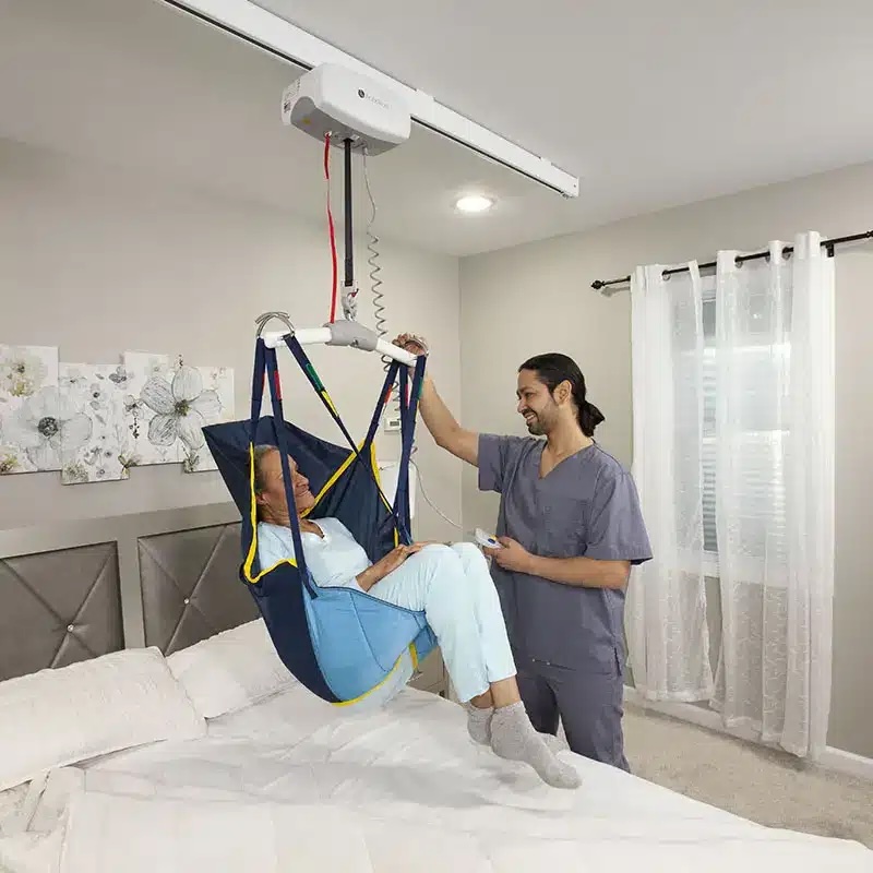 caregiver transferring patient using fixed ceiling lift by Lifeway Mobility