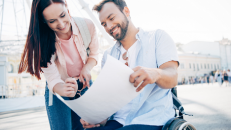 woman-helping-husband-in-wheelchair-read-a-map