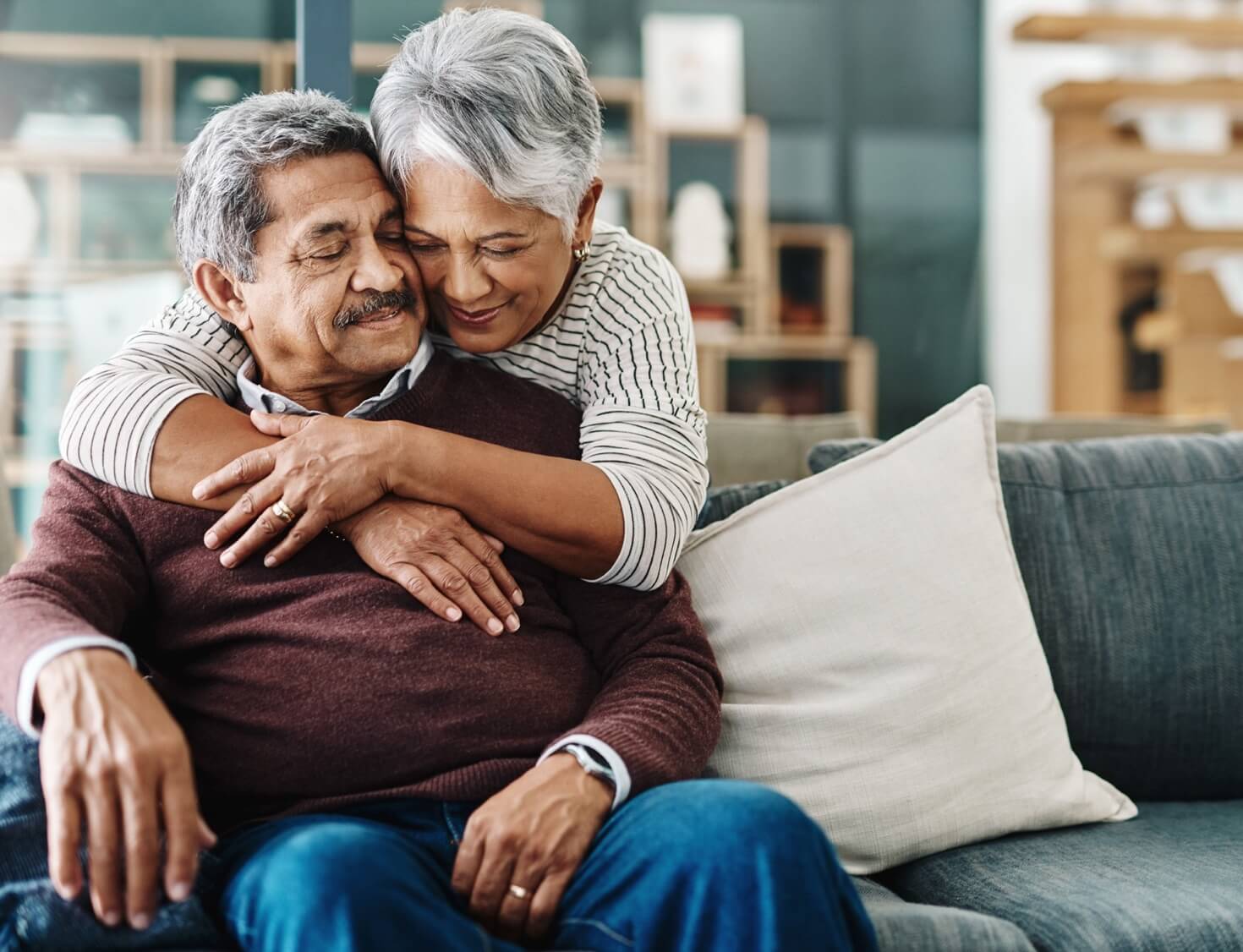 woman embraces elderly husband