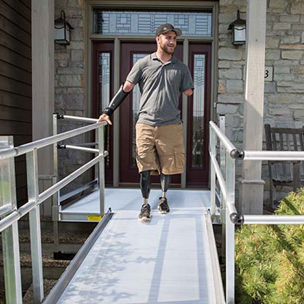 disabled man using wheelchair ramp to exit home