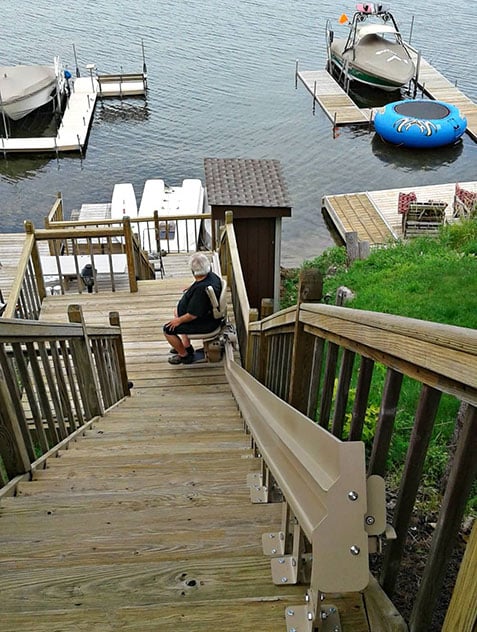 Bruno custom curved stair lift installed on staircase in a backyard that leads to Round Lake