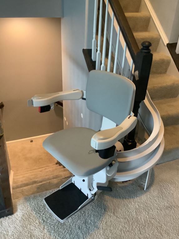 man riding curved stair lift in home