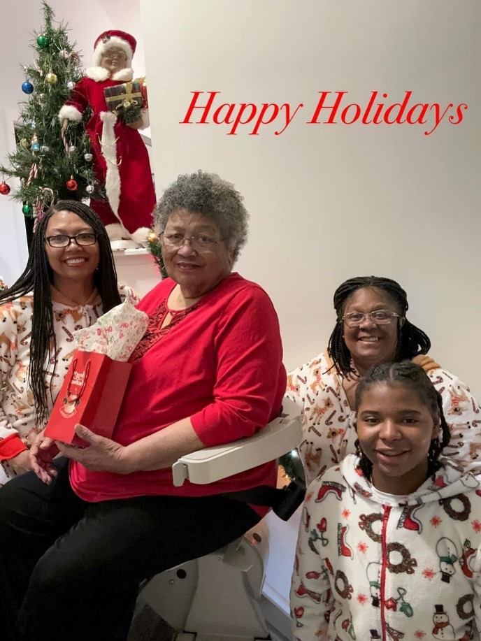 woman sitting on Lifeway Mobility stair lift with daughter and granddaughters next to her