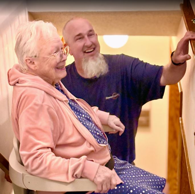 Lifeway Mobility technician smiles with customer after her first ride on stairlift