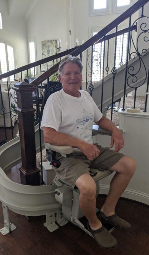 Lifeway Mobility curved stair lift customer smiling on his new lift