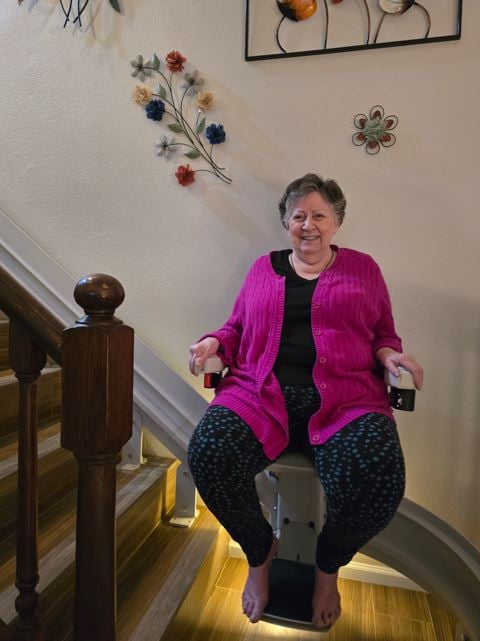 woman smiling on Lifeway Mobility stair lift