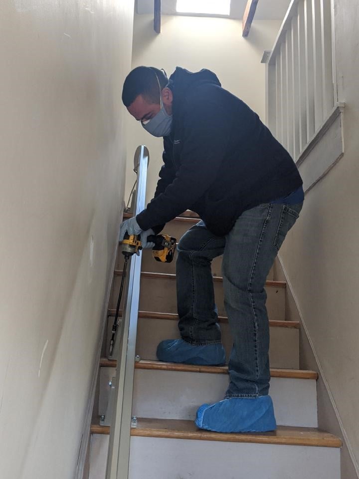 Lifeway Mobility trained technician wearing PPE installing stair lift