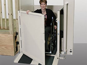 wheelchair user opens platform gate to safely exit wheelchair lift from Lifeway Mobility