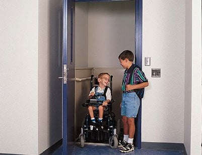 Children using a vertical platform wheelchair lift