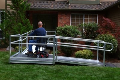 man in scooter using wheelchair ramp to safely enter home