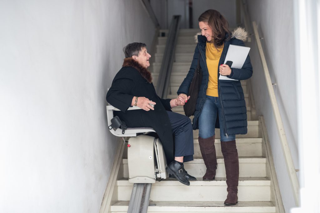 woman using stairlift to safely get down staircase