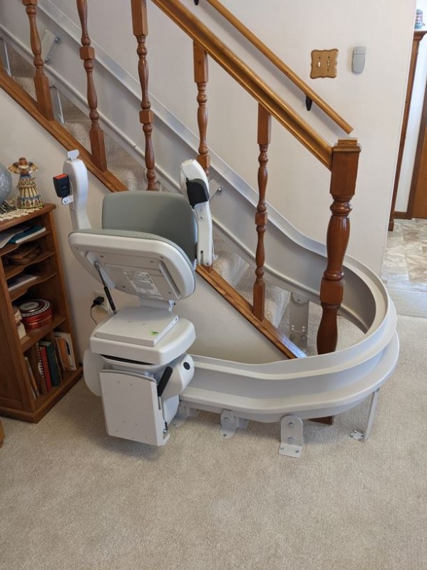 curved-stairlift-at-bottom-landing-with-seat-folded-up-in-Wichita-KS-by-Lifeway-Mobility.jpg