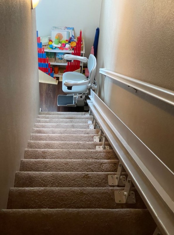 custom-curved-stairlift-at-bottom-landing-of-stairs-in-Oceanside-CA-from-Lifeway-Mobility.JPG