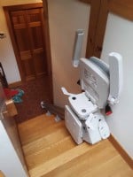 Bruno Elan stairlift components folded up at top landing in home in Weston Massachusetts