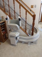 curved-stairlift-at-bottom-landing-with-seat-folded-up-in-Wichita-KS-by-Lifeway-Mobility.jpg