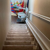 custom curved stairlift at bottom landing of stairs in Oceanside CA from Lifeway Mobility