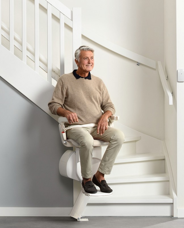 man riding Otolift stair lift by Lifeway Mobility