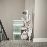 Bruno Elite curved stairlift at top landing side view seat folded from Lifeway Mobility