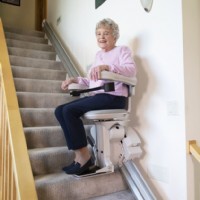 woman riding new Bruno Elite stairlift with new seat Lifeway Mobility