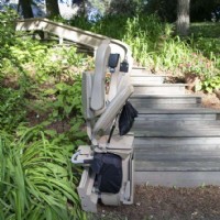 Bruno outdoor curved stairlift with new seat side view with chair folded up